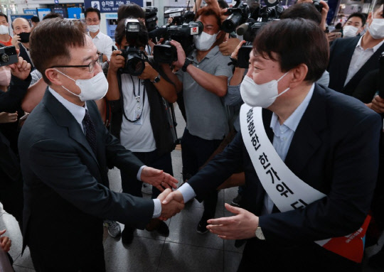 국민의힘 윤석열(오른쪽), 최재형 대선 경선 예비후보가 추석 연휴를 맞아 지난 9월 19일 서울역 대합실에서 각각 시민들에게 명절 인사를 하던 중 만나 악수를 하고 있다. [사진=연합뉴스]